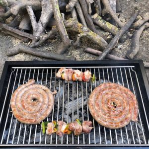 Due salsicce e due spiedini grigliati sul barbecue a carbone con girarrosto USB, realizzato da Allegri Girarrosti