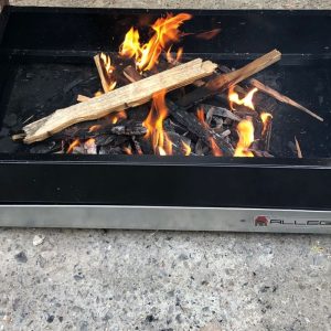 Un piccolo barbecue a legna prodotto da Allegri girarrosti con legna e rami, colore nero e argento